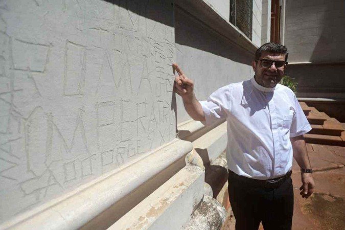 Padre George Raleb Massis mostra o resultado da ação de vândalos na fachada da Igreja, um dos muitos problemas do local