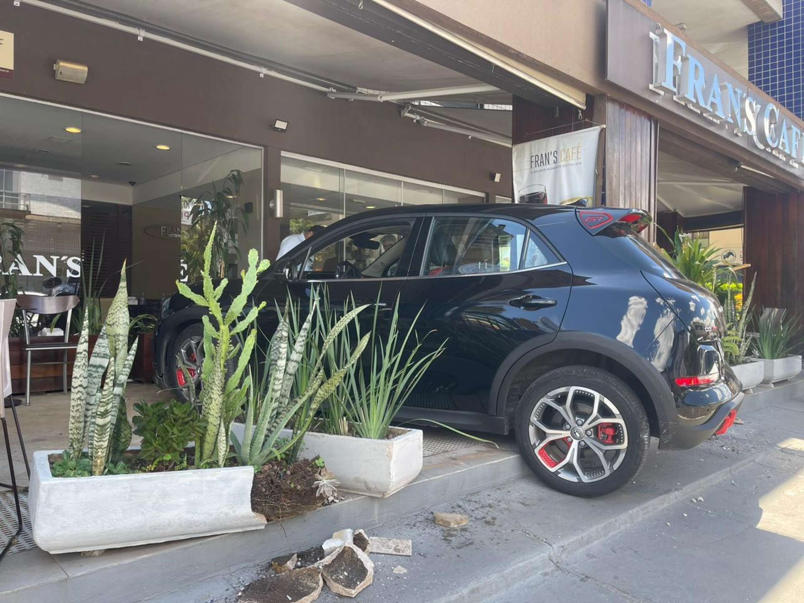 Um carro el&eacute;trico da marca Ora, de cor preta, invadiu uma cafeteria na comercial da 209 Norte