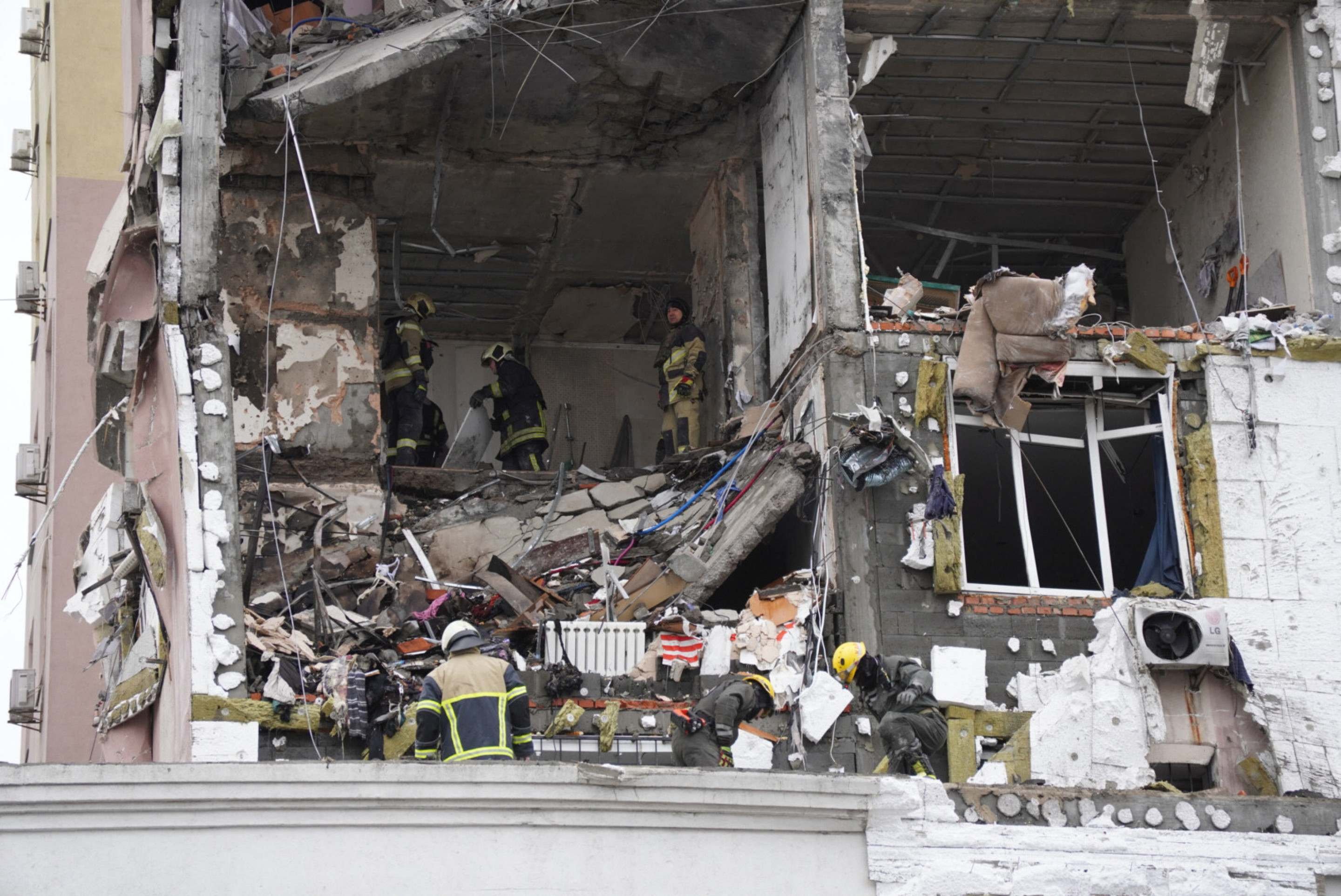 Socorristas ucranianos vasculham escombros de pr&eacute;dio atingido por m&iacute;sseis e drones russos, em Kiev, no s&aacute;bado       