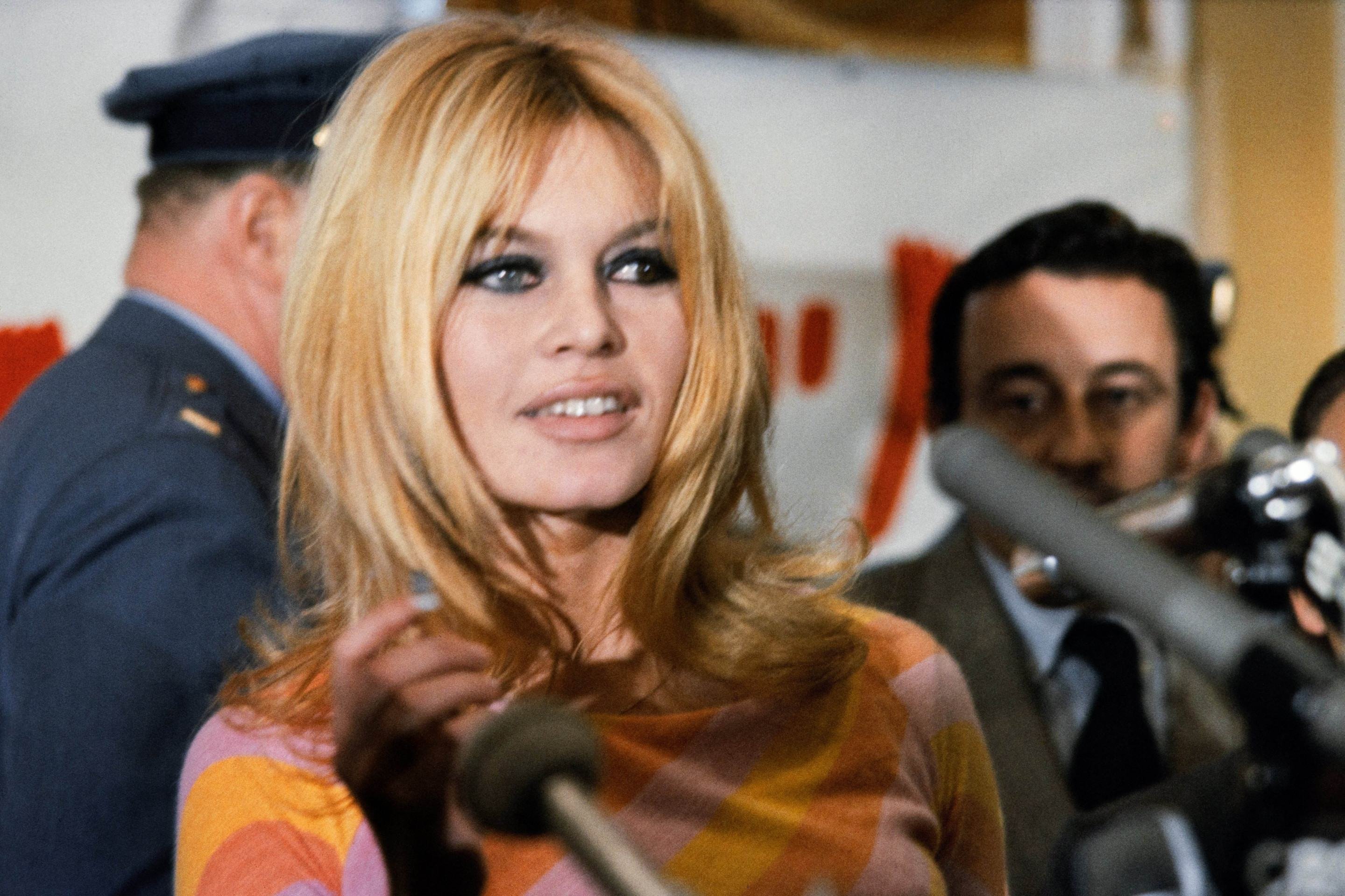 A atriz francesa Brigitte Bardot concede uma entrevista coletiva em dezembro de 1965 em Hollywood para o filme 'Viva Maria', dirigido por Louis Malle (ao fundo)      