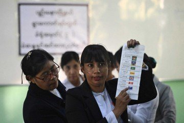 Membros da Comissão Eleitoral da União (UEC) de Mianmar contam cédulas após o fechamento das urnas em um centro de votação na primeira fase das eleições gerais de Mianmar, em Naypyidaw, em 28 de dezembro de 2025 -  (crédito: Sai Aung MAIN / AFP)
