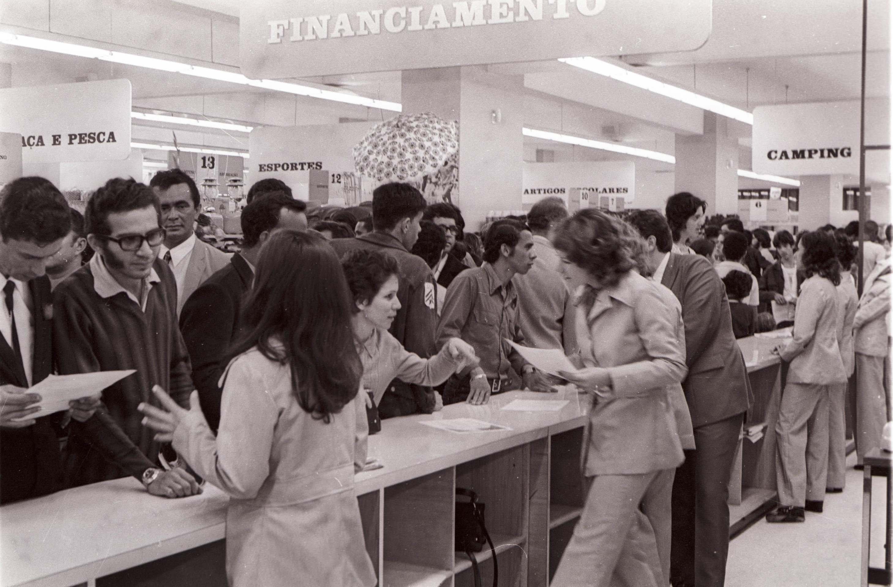  24/11/1971. Cr&eacute;dito: Arquivo CB/D.A Press. Brasil. Bras&iacute;lia - DF. Inaugura&ccedil;&atilde;o do Conjunto Nacional. Pessoas pr&oacute;ximas a balc&atilde;o da ag&ecirc;ncia do Banco Industrial de Campina Grande, que financia as compras dos clientes do P&atilde;o de A&ccedil;&uacute;car, dentro do supermercado Jumbo no dia de sua inaugura&ccedil;&atilde;o. CB, 25/11/1971. P&aacute;g. 6;          Caption 