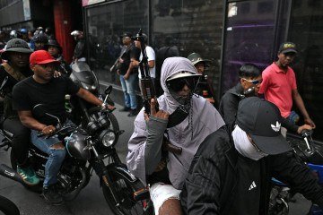 Milicianos chavistas desfilam armados em  Caracas:  tragédia humana mobiliza pouco -  (crédito:  Juan BARRETO / AFP)