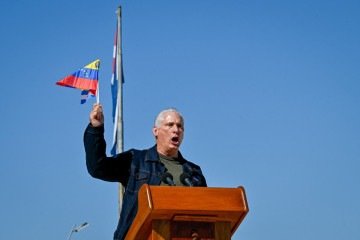 Presidente de Cuba, Miguel Díaz-Canel balança bandeira da Venezuela durante ato em Havana   -  (crédito: AFP)