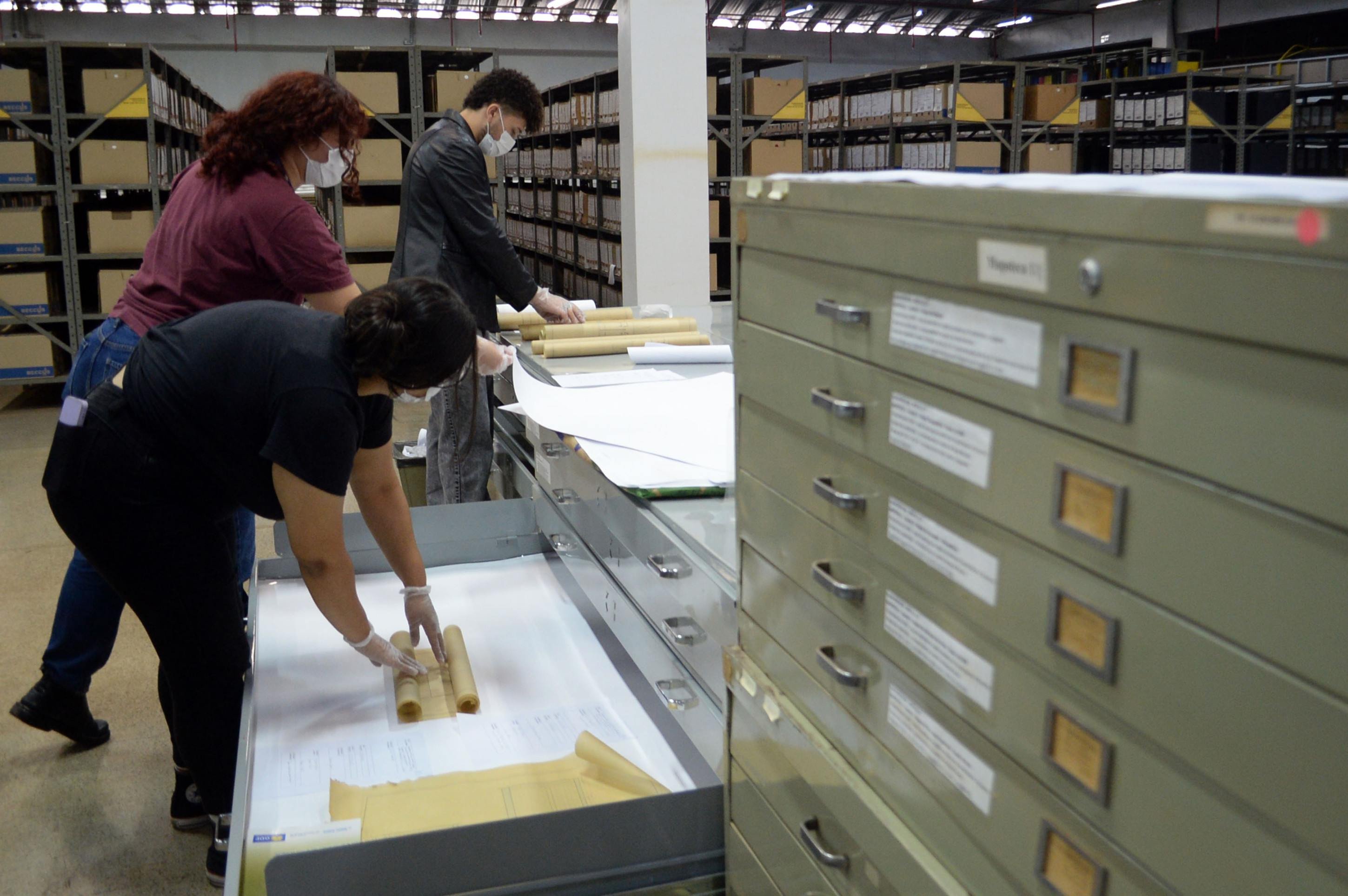 Estagi&aacute;rios manuseiam arquivos 