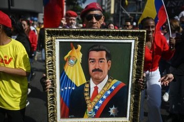 Um homem segura uma foto do presidente Nicolás Maduro durante um comício em apoio a ele e Cilia Flores, em Caracas, em 6 de janeiro de 2026. Eles foram capturados há um mês, em 3 de janeiro, pelo governo dos EUA -  (crédito:  AFP)