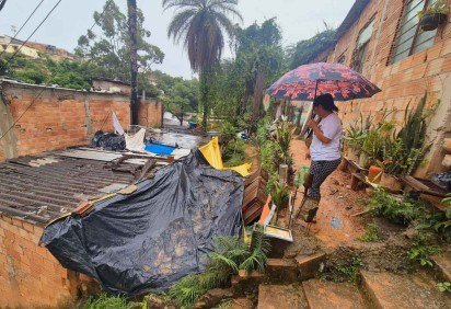 A líder comunitária Geni Mendes mostra barracões cobertos de lona numa tentativa de conter os efeitos dos temporais: 'Todo ano passamos por isso (...), com barrancos cedendo' -  (crédito: Jair Amaral/EM/D.A Press)