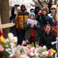 Imagens que circulam nas redes sociais mostram um agente do ICE mascarado tentando abrir a porta do veículo da mulher, um SUV Honda Pilot, enquanto ela tentava manobrar para sair do local -  (crédito: AFP)