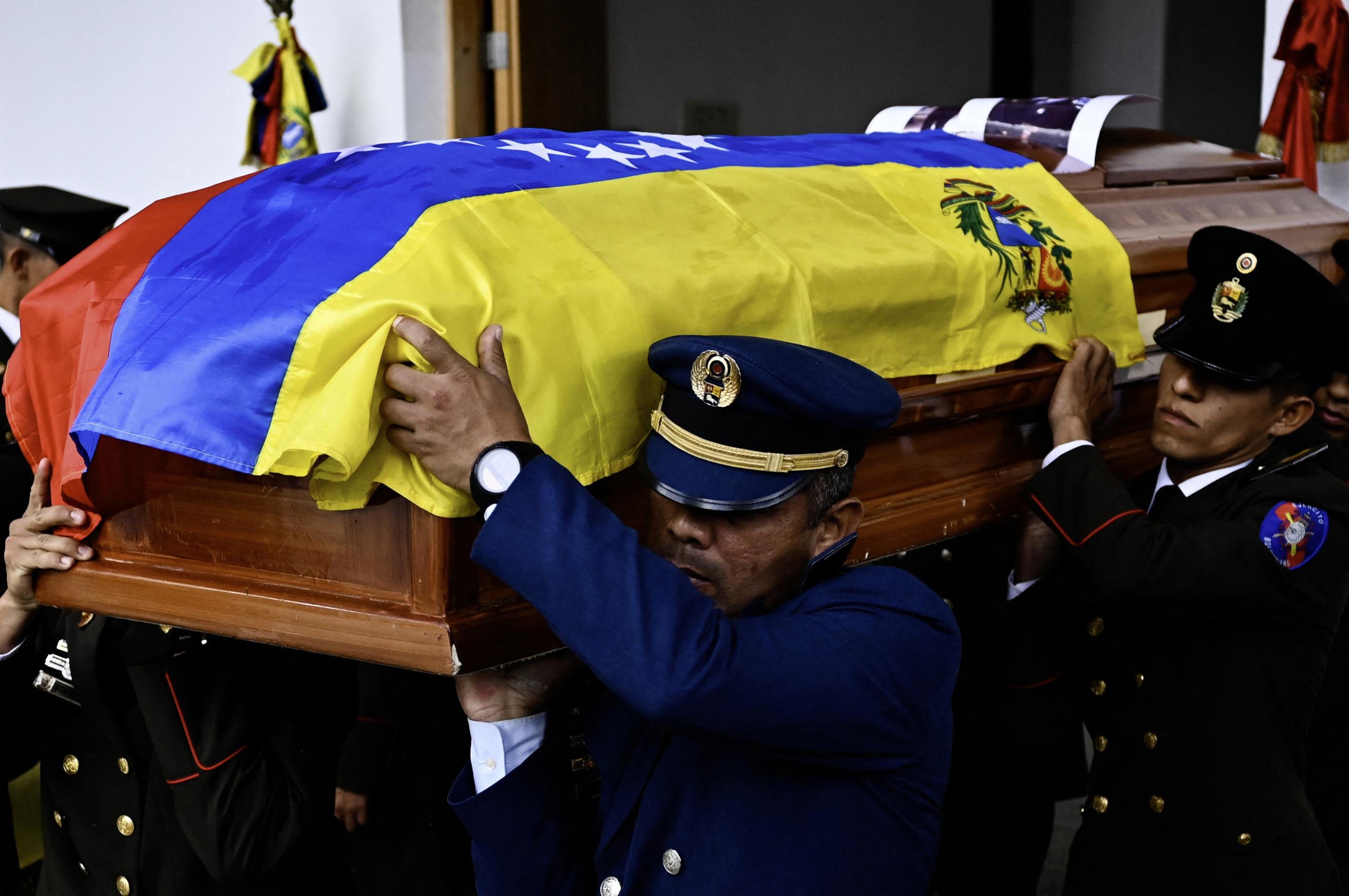 Membros da For&ccedil;a Armada Nacional Bolivariana carregam caix&atilde;o de colega morto no ataque dos EUA, em Caracas