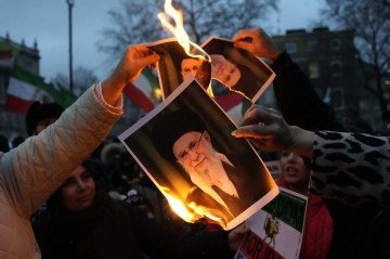 Manifestantes queimam imagens do aiatolá Ali Khamenei durante um protesto em solidariedade à revolta iraniana, organizado pelo Conselho Nacional da Resistência do Irã, em Whitehall, no centro de Londres, em 11 de janeiro de 2026       -  (crédito: CARLOS JASSO / AFP)