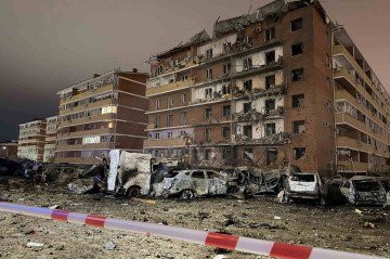 Esta imagem, divulgada em 21 de janeiro de 2026 na conta oficial do Telegram de Murat Kumpilov, chefe da República da Adiguésia, na Rússia, mostra um prédio residencial e um estacionamento danificados após um ataque de drone no distrito de Takhtamukaysky, na república       -  (crédito: HANDOUT / TELEGRAM / MURATKUMPILOV / AFP)