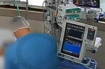 Técnico de enfermagem em leito onde morreu uma das vítimas - (crédito: Reprodução/Câmeras de segurança) Técnico de enfermagem em leito onde morreu uma das vítimas - (crédito: Reprodução/Câmeras de segurança)