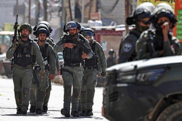 Membros das forças de segurança israelenses patrulham uma rua durante uma operação militar no bairro de Kafr Aqab, perto de Ramallah, na Cisjordânia ocupada por Israel, em 26 de janeiro de 2026       -  (crédito: ZAIN JAAFAR / AFP)
