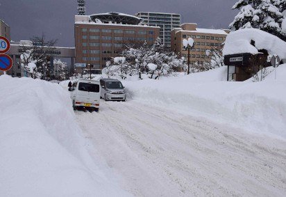 Pessoas transitam por uma rua coberta de neve na cidade de Aomori, em 3 de fevereiro de 2026       -  (crédito: STR / JIJI PRESS / AFP) -Pessoas transitam por uma rua coberta de neve na cidade de Aomori, em 3 de fevereiro de 2026       -  (crédito: STR / JIJI PRESS / AFP)