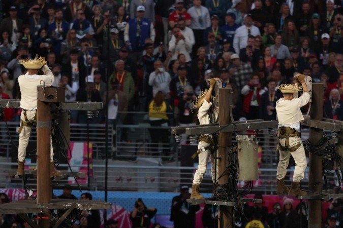 Bad Bunny performando durante o Apple Music Super Bowl LX Halftime Show; momento em que levanta a bandeira de Porto Rico