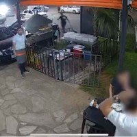 Suspeito armado aborda as vítimas em estabelecimento comercial -  (crédito: Reprodução)