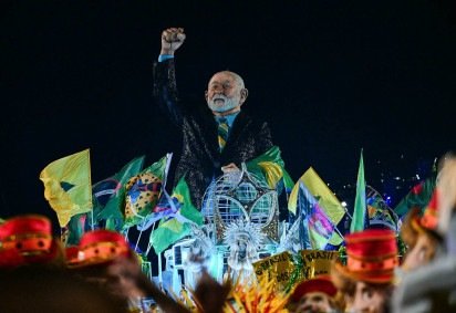Um carro alegórico representando o presidente brasileiro Luiz Inácio Lula da Silva, da escola de samba Acadêmicos de Niterói, é visto durante a noite de abertura do Carnaval do Rio, no Sambódromo Marquês de Sapucaí, no Rio de Janeiro, Brasil, em 15 de fevereiro de 2026       -  (crédito: PABLO PORCIUNCULA / AFP)