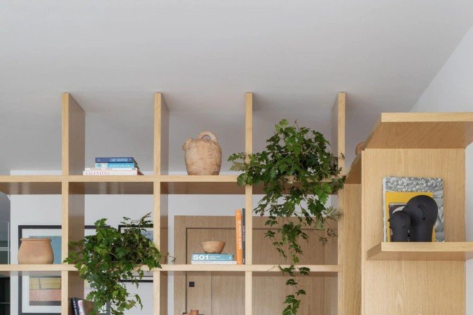 Estantes divisórias delimitam o ambiente e oferecem prateleiras. Projeto de Beta Arquitetura