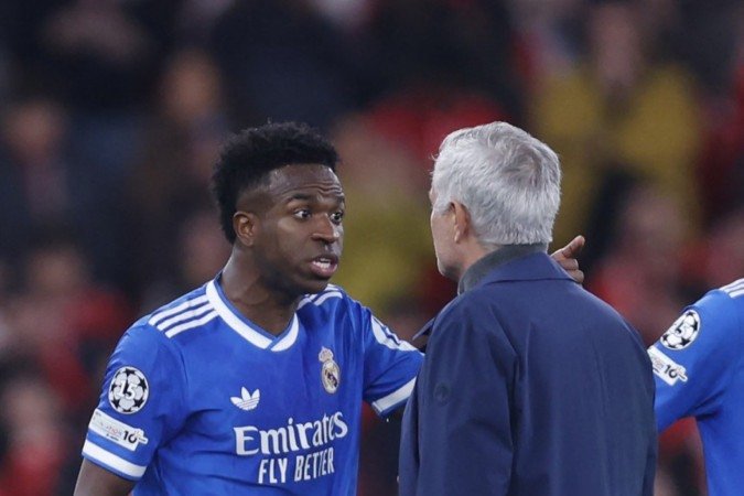 Real Madrid's Brazilian forward #07 Vinicius Junior talks with SL Benfica's Portuguese head coach Jose Mourinho after listening racists insults during the UEFA Champions League knockout round play-off first leg football match between SL Benfica and Real Madrid CF at Estadio da Luz in Lisbon on February 17, 2026. (Photo by FILIPE AMORIM / AFP)
- (crédito: Filipe Amorim/AFP) Real Madrid's Brazilian forward #07 Vinicius Junior talks with SL Benfica's Portuguese head coach Jose Mourinho after listening racists insults during the UEFA Champions League knockout round play-off first leg football match between SL Benfica and Real Madrid CF at Estadio da Luz in Lisbon on February 17, 2026. (Photo by FILIPE AMORIM / AFP)
- (crédito: Filipe Amorim/AFP)