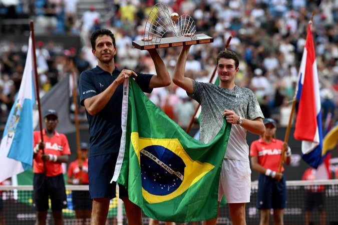 A dupla brasileira Marcelo Melo (E) e João Fonseca vence a final de duplas masculinas no torneio de tênis Rio Open - (crédito: MAURO PIMENTEL / AFP) A dupla brasileira Marcelo Melo (E) e João Fonseca vence a final de duplas masculinas no torneio de tênis Rio Open - (crédito: MAURO PIMENTEL / AFP)