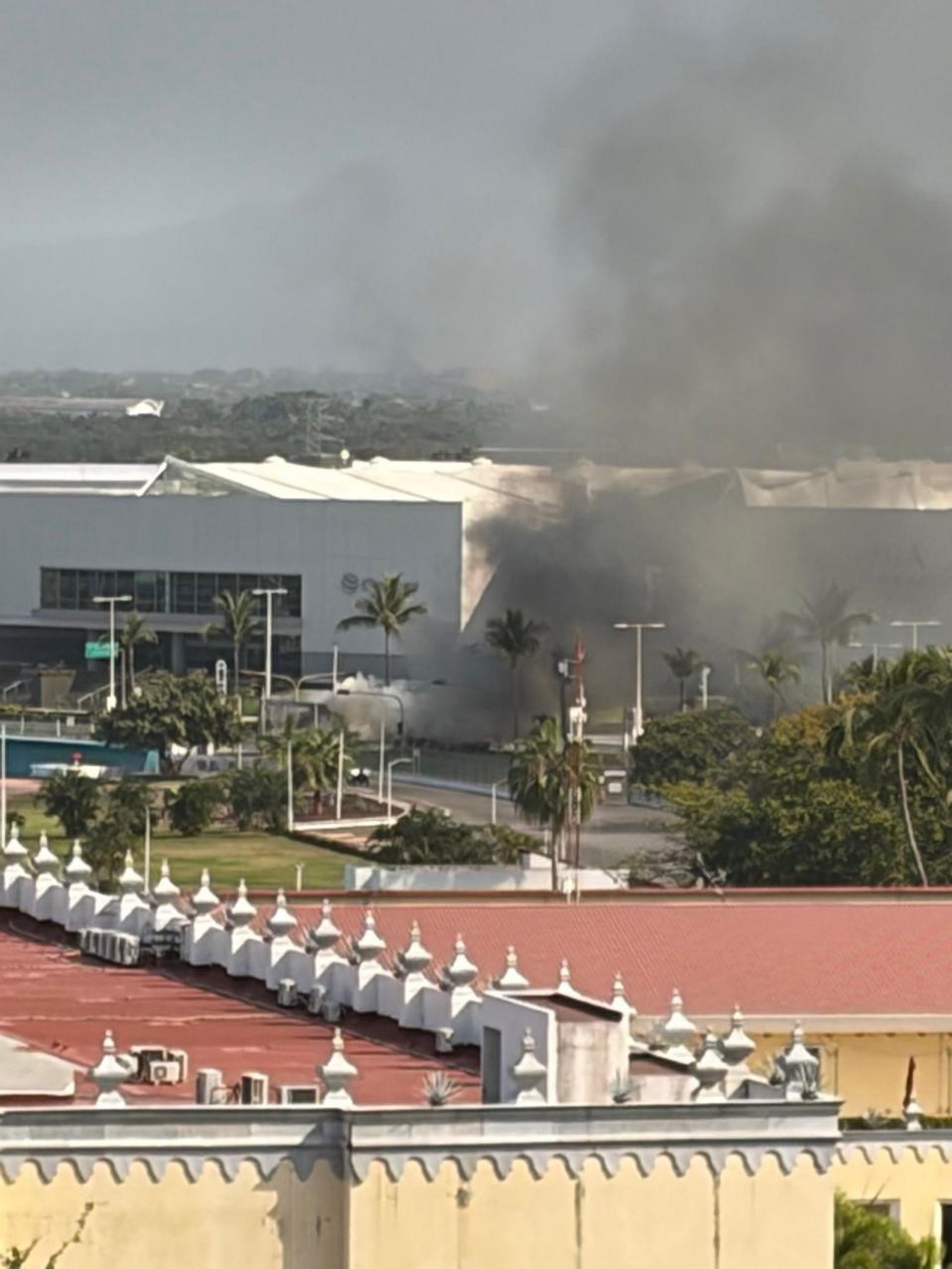 Vista de barricada em chamas a partir de terra&ccedil;o de hotel em Puerto Vallarta 