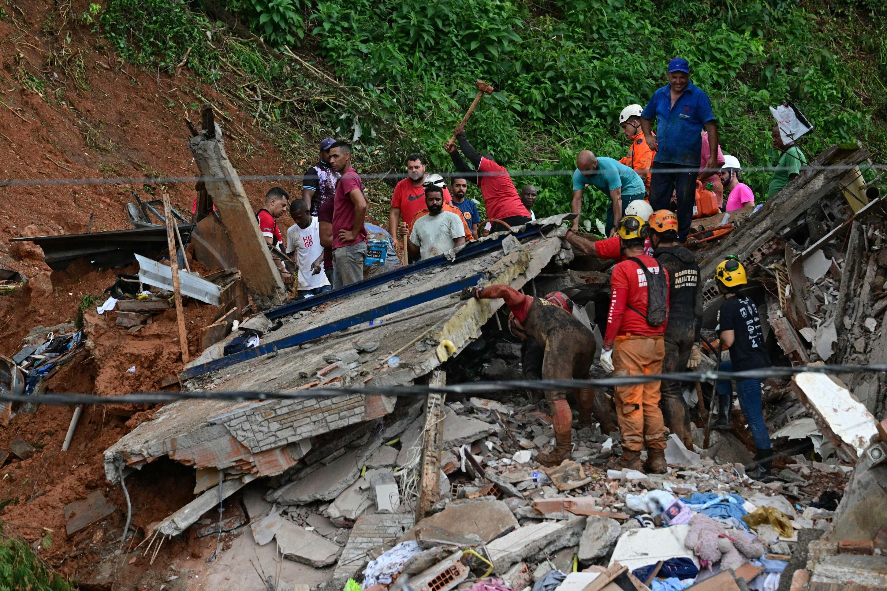 Equipes de resgate removem destroços em busca de vítimas de um deslizamento de terra causado por fortes chuvas no bairro Parque Jardim Burnier, em Juiz de Fora, Minas Gerais, Brasil, em 24 de fevereiro de 2026      -PABLO PORCIUNCULA / AFP