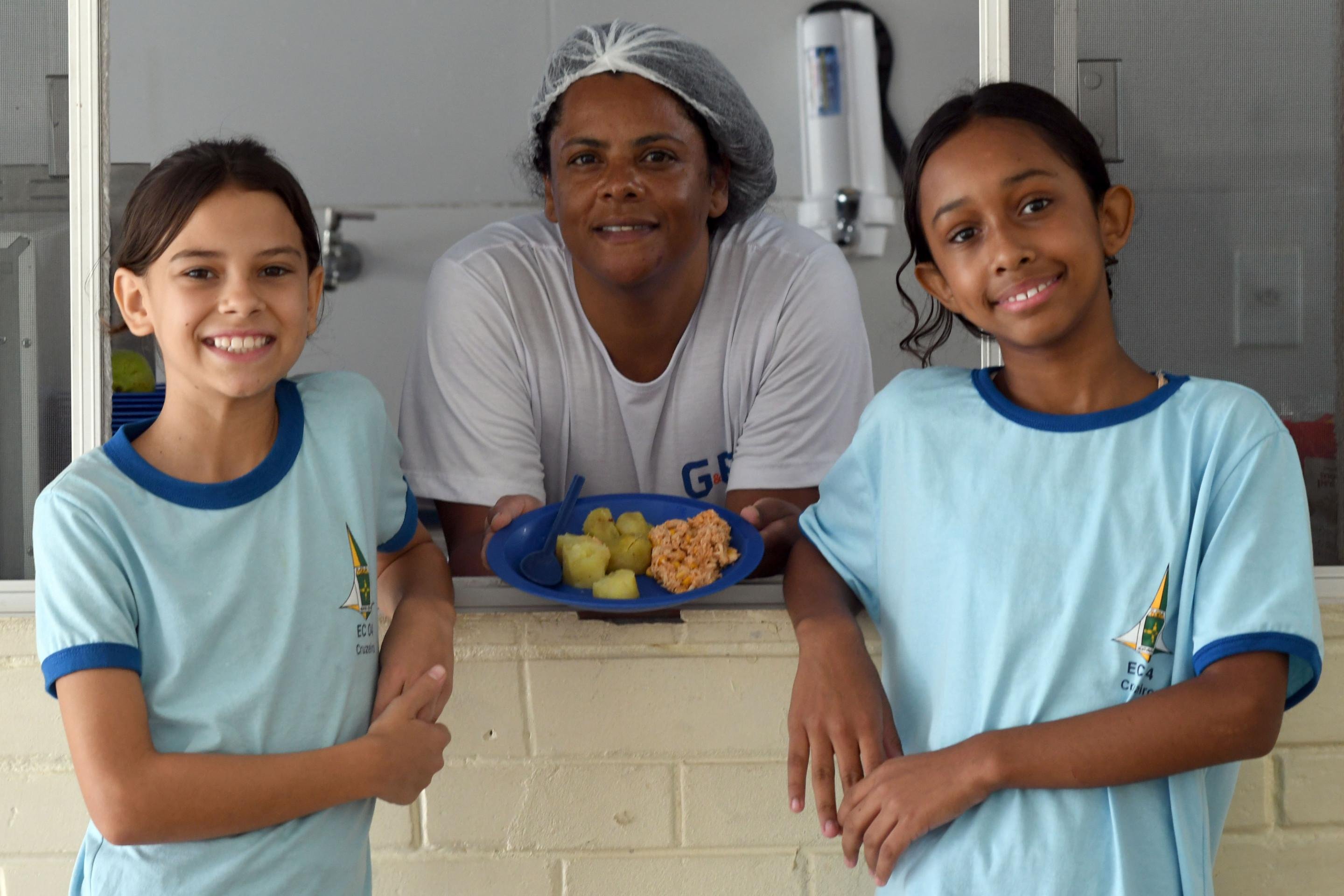 A merendeira K&aacute;tia Lopes entre as estudantes Eloisa Vitelli e Laura Ramos (da esquerda para a direita)