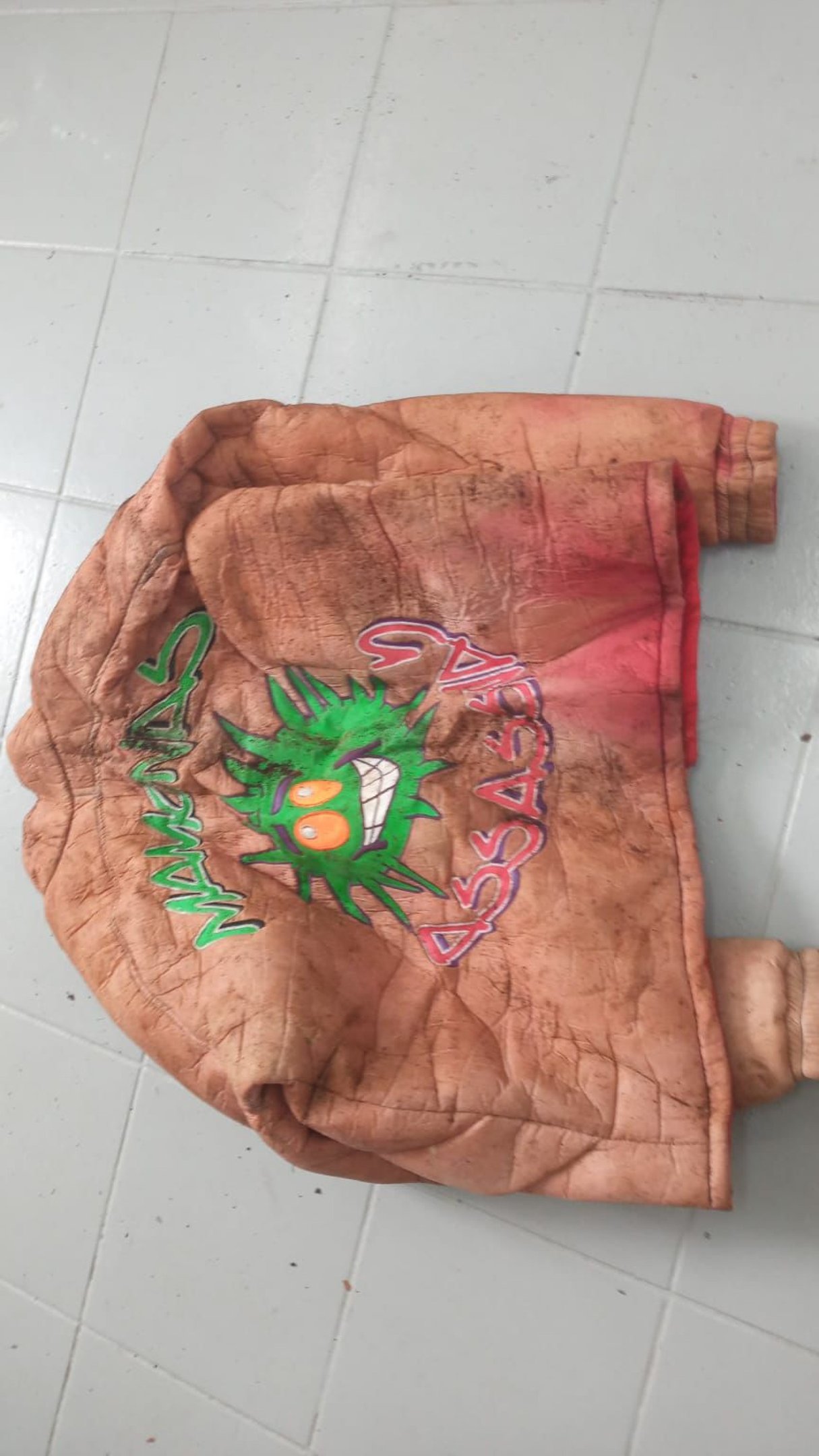 Pe&ccedil;a traz a bandeira do Brasil na frente e o s&iacute;mbolo da banda nas costas.