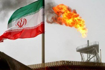 Tocha de gás em uma plataforma de produção de petróleo é vista ao lado de uma bandeira iraniana no Golfo Pérsico, única saída ao mar aberto - (crédito: Raheb Homavandi/File Photo/Reuters) Tocha de gás em uma plataforma de produção de petróleo é vista ao lado de uma bandeira iraniana no Golfo Pérsico, única saída ao mar aberto - (crédito: Raheb Homavandi/File Photo/Reuters)