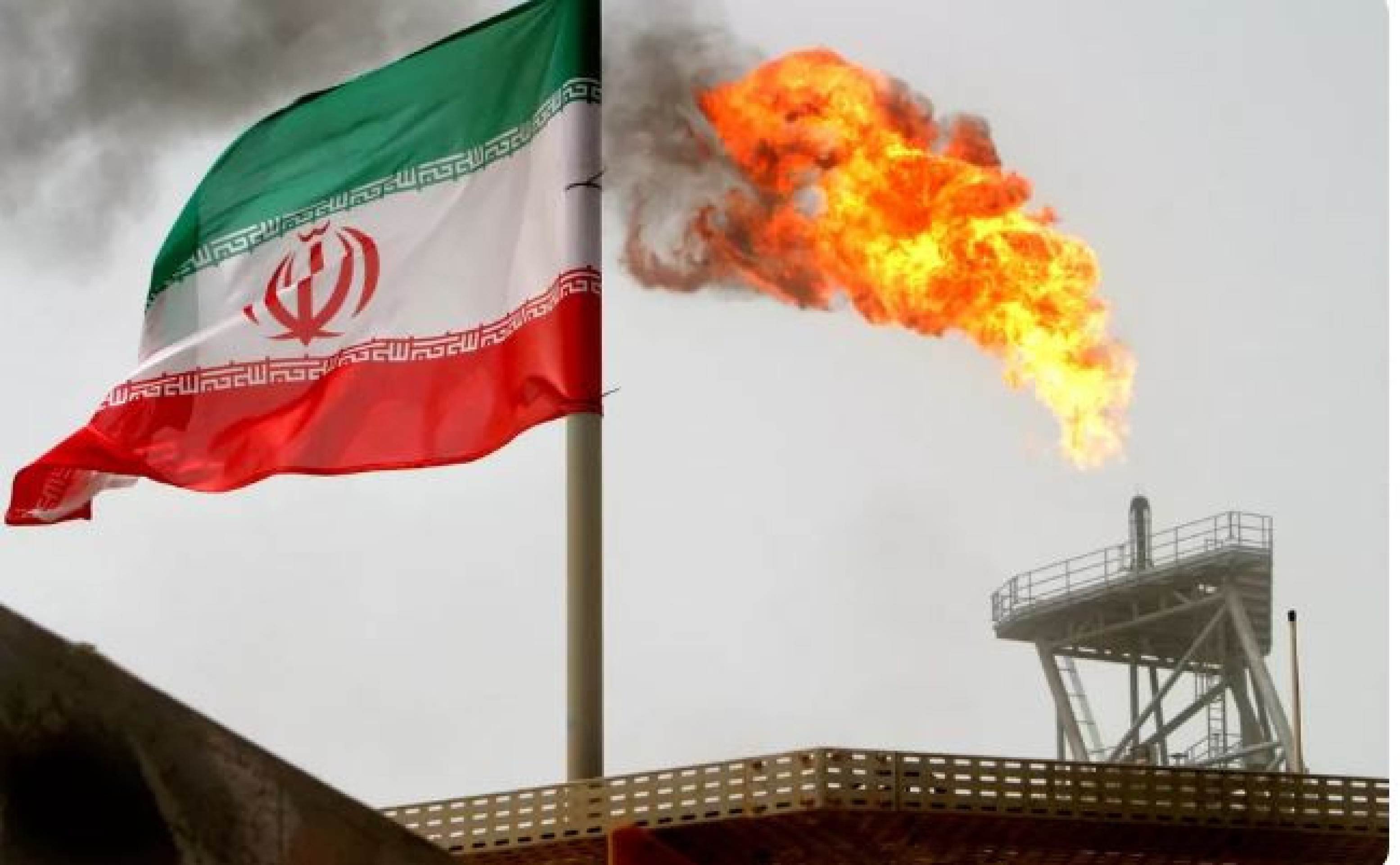 Tocha de gás em uma plataforma de produção de petróleo é vista ao lado de uma bandeira iraniana no Golfo Pérsico, única saída ao mar aberto -  (crédito: Raheb Homavandi/File Photo/Reuters)