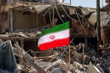 Bandeira iraniana colocada sobre escombros de prédio destruído por mísseis, em Teerã
- (crédito: Atta Kenare/AFP) Bandeira iraniana colocada sobre escombros de prédio destruído por mísseis, em Teerã
- (crédito: Atta Kenare/AFP)