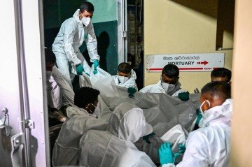 Profissionais de saúde do Sri Lanka carregam os corpos de marinheiros iranianos, no necrotério do hospital Karapitiya, em Galle -  (crédito: Ishara S. Kodikara/AFP)
