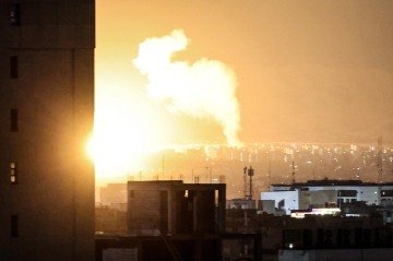 Fumaça e fogo se levantam de local atingido por bombardeios, na região central de Teerã, capital iraniana  -  (crédito: Atta Kenare/AFP)