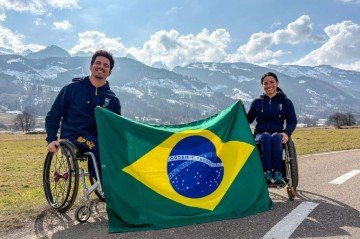 Esquiadores Cristian Ribera e Aline Rocha seguram a bandeira do Brasil em Predazzo, na Itália: a missão é deles na cerimônia de abertura -  (crédito: Alessandra Cabral/CPB)