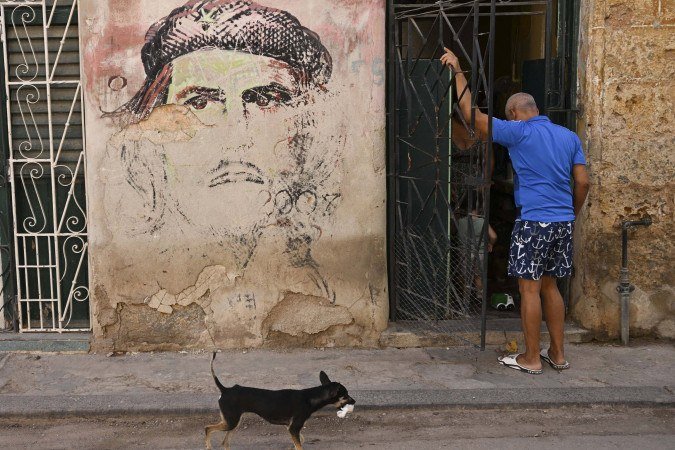 Morador de Havana na porta de casa, com a figura de Ernesto 