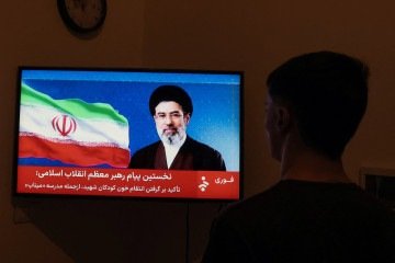 Homem assiste a declaração de Mojtaba Khamenei pela televisão: sem imagens de vídeo nem voz  -  (crédito: AFP)