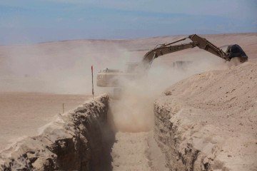 Esta vista mostra maquin&aacute;rio pesado operando pr&oacute;ximo ao posto fronteiri&ccedil;o de Chacalluta, ao longo da fronteira entre o Chile e o Peru, em 16 de mar&ccedil;o de 2026. O presidente do Chile, Jos&eacute; Antonio Kast, lan&ccedil;ou um projeto de vala na fronteira para conter a migra&ccedil;&atilde;o ilegal. -  (crédito: Photo by Patricio BANDA / AFP)