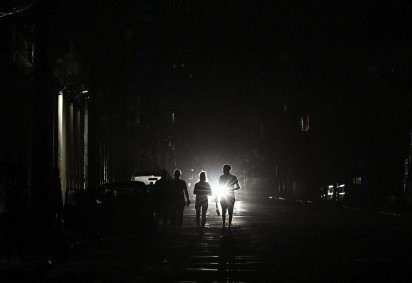 Pessoas caminham durante um apagão nacional em Havana, em 21 de março de 2026.  -  (crédito: YAMIL LAGE / AFP) -Pessoas caminham durante um apagão nacional em Havana, em 21 de março de 2026.  -  (crédito: YAMIL LAGE / AFP)