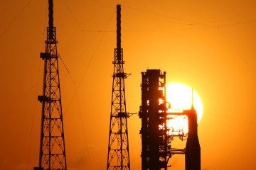  NASA's Artemis II Space Launch System (SLS) rocket and Orion spacecraft are seen at sunrise at Launch Pad 39B at the Kennedy Space Center in Cape Canaveral, Florida on March 24, 2026. NASA on March 19 began returning its towering SLS rocket and Orion spacecraft to its Florida launch pad ahead of a planned flyby of the Moon, after completing necessary repairs. The next launch window opens on April 1. (Photo by Gregg Newton / AFP)
       -  (crédito:  AFP) - NASA's Artemis II Space Launch System (SLS) rocket and Orion spacecraft are seen at sunrise at Launch Pad 39B at the Kennedy Space Center in Cape Canaveral, Florida on March 24, 2026. NASA on March 19 began returning its towering SLS rocket and Orion spacecraft to its Florida launch pad ahead of a planned flyby of the Moon, after completing necessary repairs. The next launch window opens on April 1. (Photo by Gregg Newton / AFP)
       -  (crédito:  AFP)
