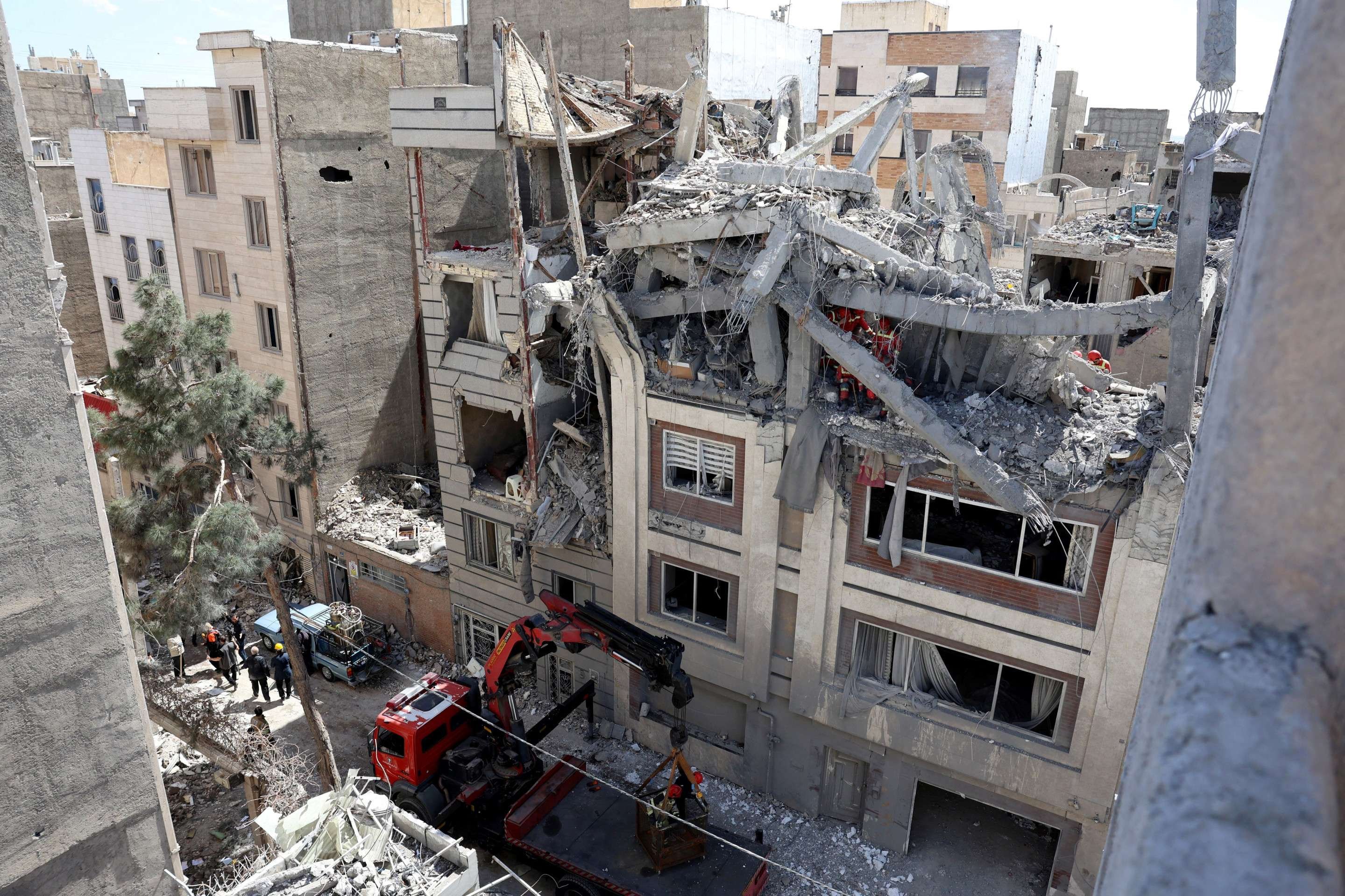 Bombeiros buscam v&iacute;timas e inspecionam danos em pr&eacute;dio destru&iacute;do por m&iacute;ssil, no sul de Teer&atilde; 