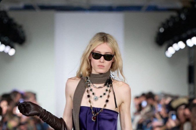 Vestido fluido, meia-calça e acessórios marcantes reforçam o glamour effortless da década