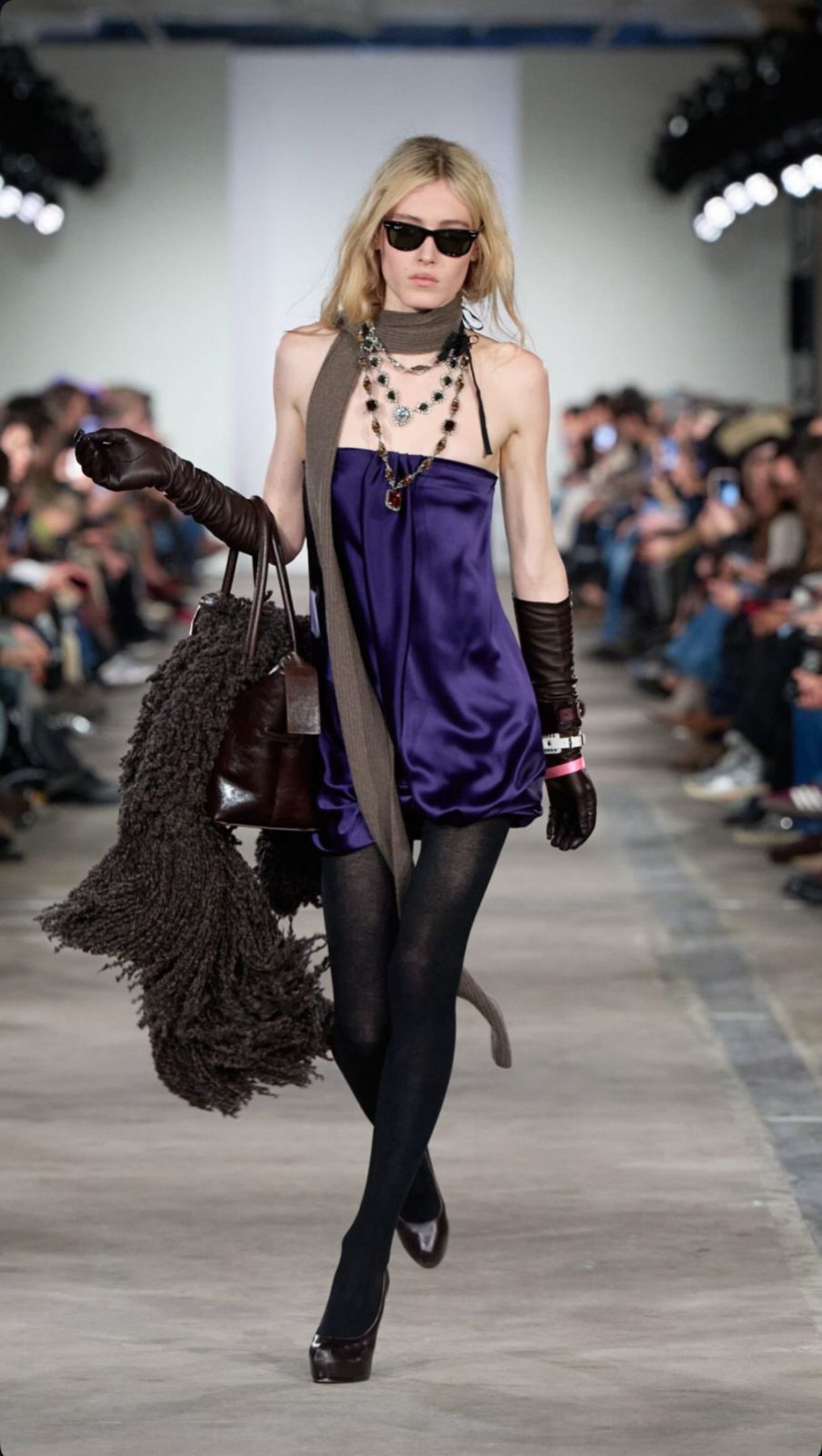Vestido fluido, meia-cal&ccedil;a e acess&oacute;rios marcantes refor&ccedil;am o glamour effortless da d&eacute;cada