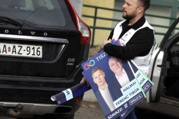 Um ativista do partido TISZA está em uma barraca de campanha, fazendo campanha para a oposição na cidade de Jaszfenyszaru, Hungria, a 50 quilômetros a leste de Budapeste, em 23 de março de 2026   -  (crédito: PETER KOHALMI / AFP)