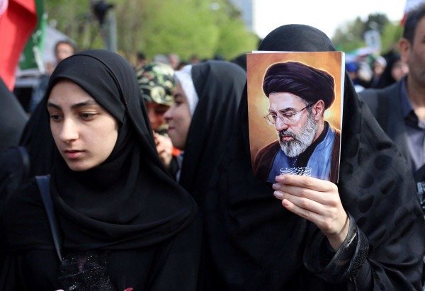 Iraniana exibe foto do líder supremo Mojtaba Khamenei durante tributo às meninas mortas em escola, em Minab: entre a tensão e o alívio -  (crédito: AFP)