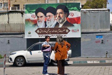 Mulheres posam em frente a um cartaz com retratos do falecido líder supremo do Irã, o aiatolá Ali Khamenei (C), do falecido aiatolá Ruhollah Khomeini (E) e do novo líder supremo Mojtaba Khamenei, em uma rua de Teerã, em 12 de abril de 2026 Created - (crédito: ATTA KENARE / AFP) Mulheres posam em frente a um cartaz com retratos do falecido líder supremo do Irã, o aiatolá Ali Khamenei (C), do falecido aiatolá Ruhollah Khomeini (E) e do novo líder supremo Mojtaba Khamenei, em uma rua de Teerã, em 12 de abril de 2026 Created - (crédito: ATTA KENARE / AFP)