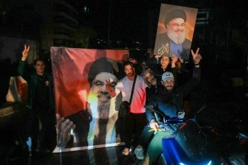 Simpatizantes do Hezbollah celebram com fotos do xeque Hassan Nasrallah, líder  assassinado em 2024: festa no sul de Beirute  -  (crédito: Ibrahim Amro/AFP)