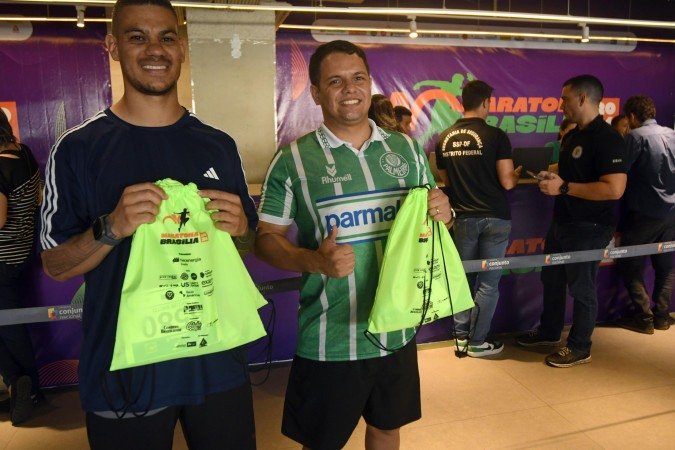  Artur de Brito e Deyvid Alves pegam os kits 
da Maratona Brasília no Conjunto Nacional