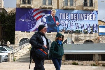 Outdoor estampado em Jerusalém com a fotografia de Trump e o termo 'O Libertador': alusão à campanha militar no Irã  -  (crédito: John Wessels/AFP)