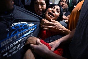 As filhas de Luis agarram-se ao pai, preso pela polícia da imigração -  (crédito: Carol Guzy)