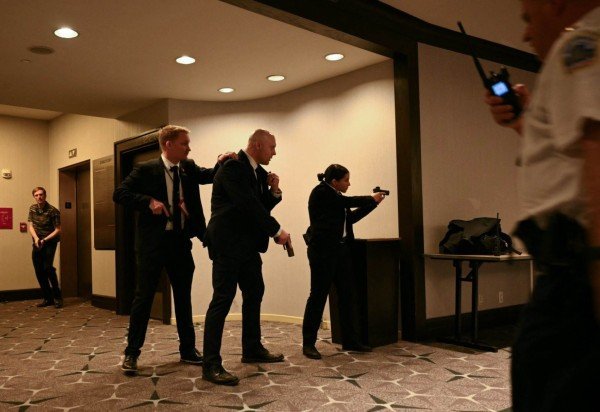 Imagens que circulam nas redes sociais mostram o momento em que Trump é escoltado rapidamente para fora do local por sua equipe de segurança -  (crédito:  AFP)